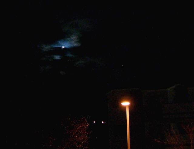The moon peeks out from behind the clouds