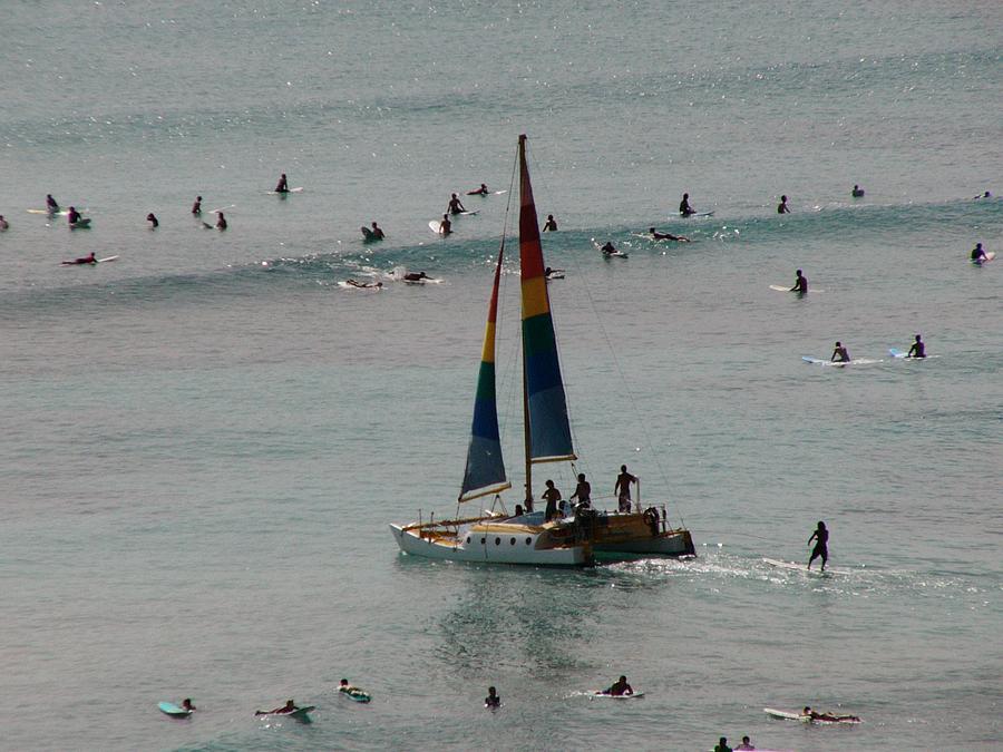 Surfers, swimmers, and boats all together at Waikiki Beach.