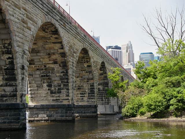 The upriver side of the Stone Arch Bridge as seen from below, with downtown in the background